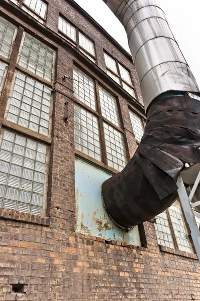 Fragmento de viejo edificio industrial con tubo de calor — Foto de Stock
