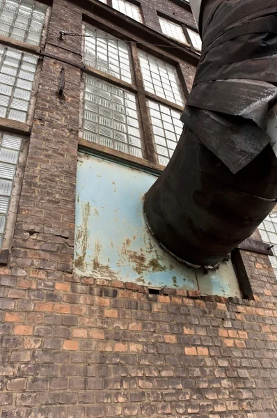 Frammento di vecchio edificio industriale con tubo di calore — Foto Stock