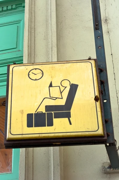 Sitzen und warten Schild in einem Bahnhof — Stockfoto
