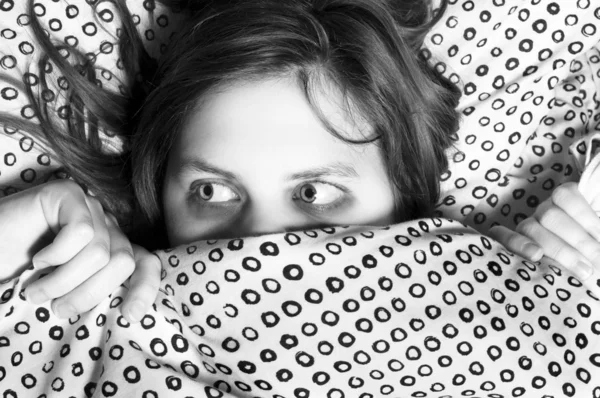 Vyděšená dívka schovává pod dekou — Stock fotografie