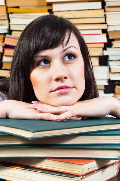 Jonge student meisje dagdromen op boeken — Stockfoto