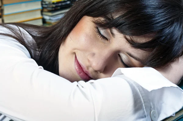 Menina estudante bonita com sorriso no rosto dormindo em livros — Fotografia de Stock