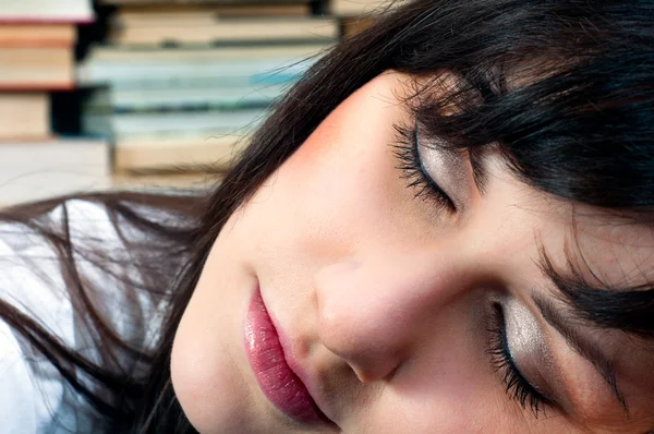Krásná mladá školačka v knihovně spaní — Stock fotografie