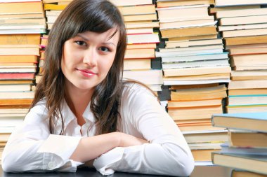 Young school girl with a lot of books against her clipart