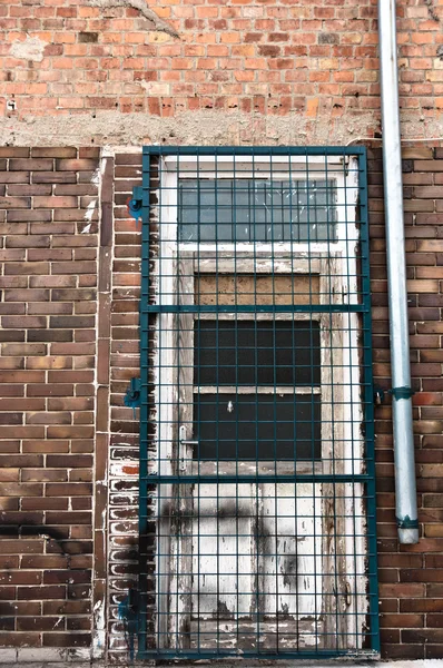 Дверь заброшенного здания с решетками — стоковое фото