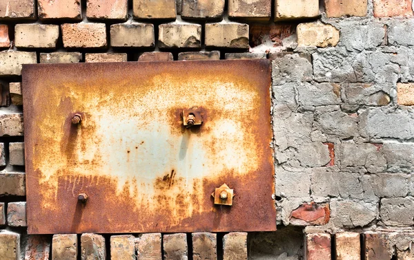 Заброшенная текстура стены с металлической пластиной — стоковое фото