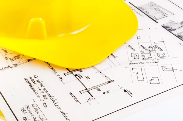 Planos de construcción con casco amarillo — Foto de Stock