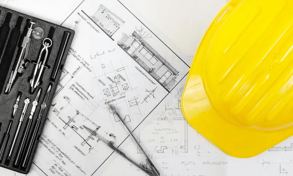 Planos de construcción con casco amarillo — Foto de Stock