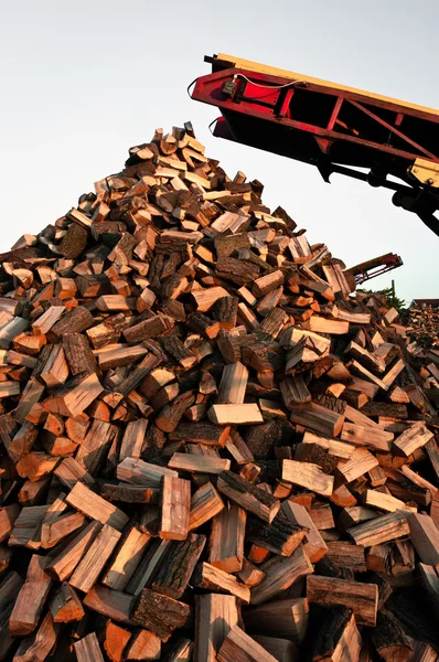 Firewood piled up with great machines — Stock Photo, Image