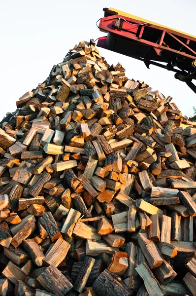 Le bois de chauffage sort d'une machine — Photo