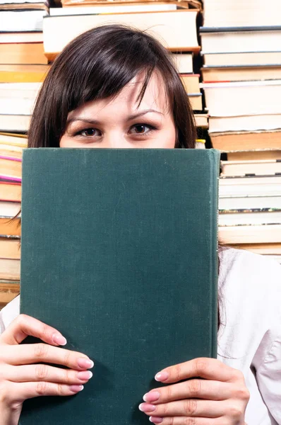 Estudante menina se escondendo atrás de livro grande — Fotografia de Stock