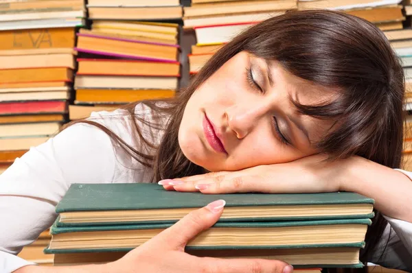 Overwerkte universiteitsstudent slapen op haar boeken — Stockfoto