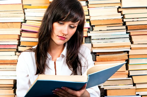 Krásná mladá studentka čtení z velké knihy — Stock fotografie