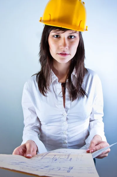 Ingegnere donna in casco giallo con piani — Foto Stock