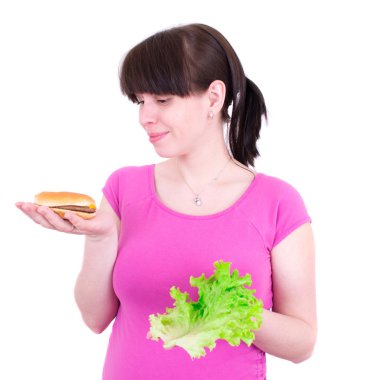 la joven mujer selecciona entre una hamburguesa y ensalada