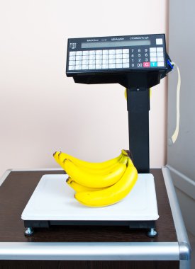 Fresh bananas on the scales in the store clipart