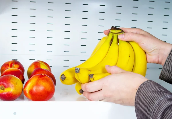 stock image Hands take bananas from store shelves