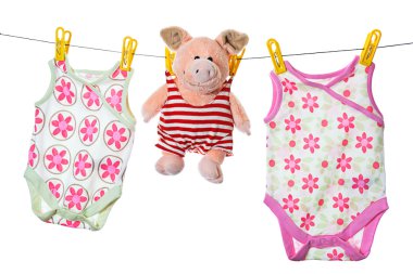 Baby sleepers and pig on the clothesline, studio isolated on whi clipart