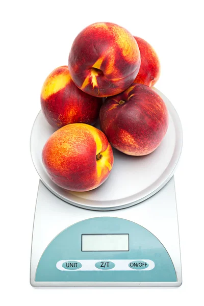 stock image Peaches on the scales on a white background