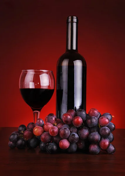 Bottle and glass of red wine with grapes — Stock Photo, Image
