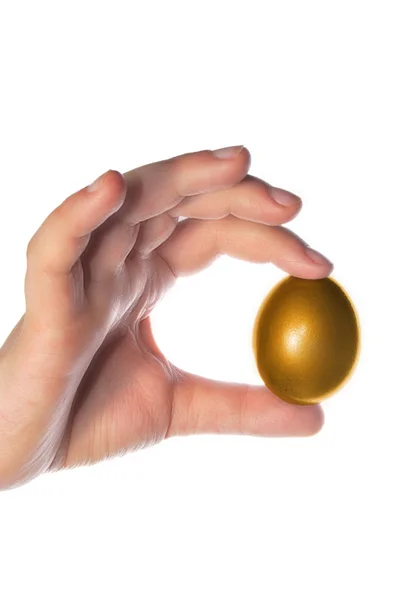 Mão segurando um ovo dourado — Fotografia de Stock