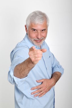 Smiling senior man pointing at camera