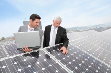 Business standing by solar panels