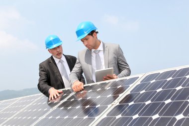 Engineers checking solar panels setup clipart