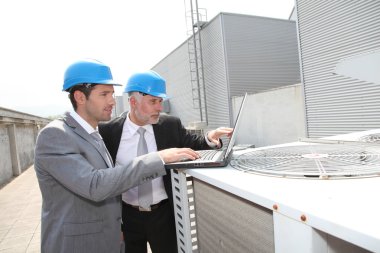 Businessmen on industrial site clipart