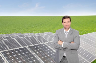 Businessman standing by photovoltaic installation clipart