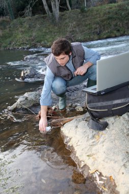 Biologists testing water of natural river clipart