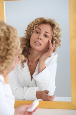 Portrait of beautiful woman applying moisturizer clipart