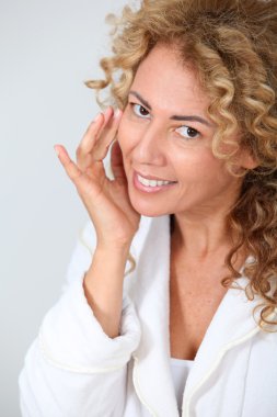 Portrait of beautiful woman looking at wrinkles in mirror clipart