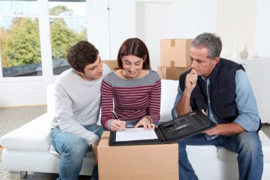 Young couple signing contract for home moving clipart