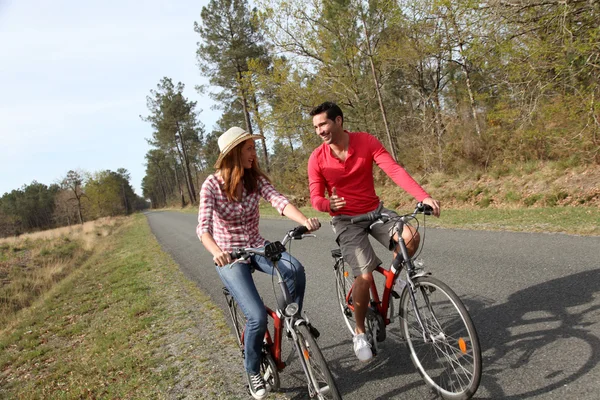 Couple riding bicycles in countryside — Stock Photo, Image
