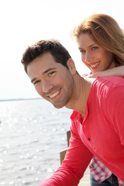 Retrato de casal sorridente em pé junto a um lago — Fotografia de Stock