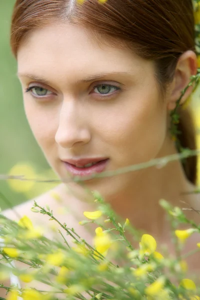 Portrait of beautiful woman in field of flowers — Stock Photo, Image