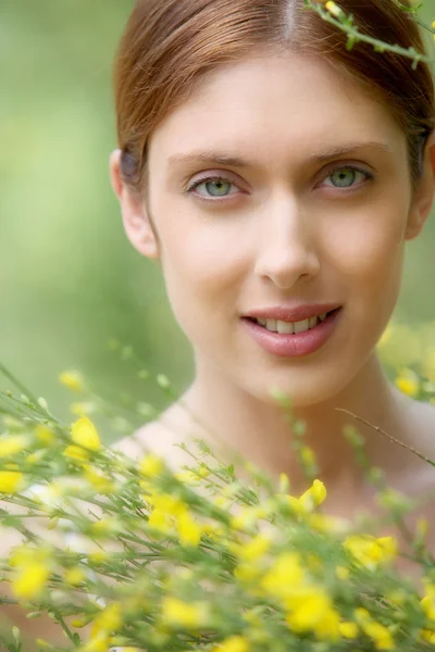Porträt einer schönen Frau im Blumenfeld — Stockfoto
