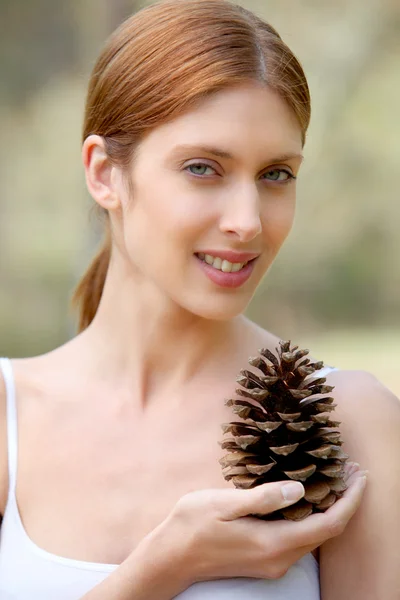 Retrato de mulher bonita segurando cone de pinho — Fotografia de Stock