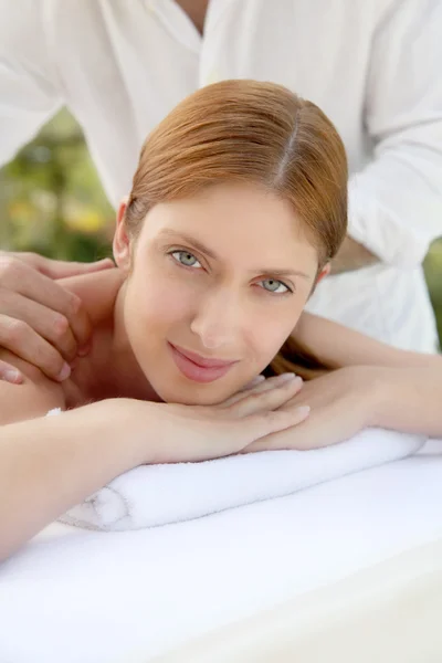 Mulher bonita que põe em uma cama de massagem — Fotografia de Stock