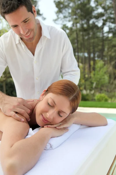 Mulher bonita que põe em uma cama de massagem — Fotografia de Stock