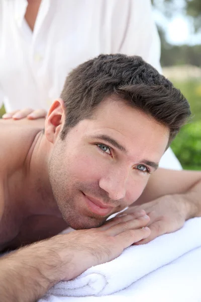 Bir masaj yatağı atarken adam — Stok fotoğraf