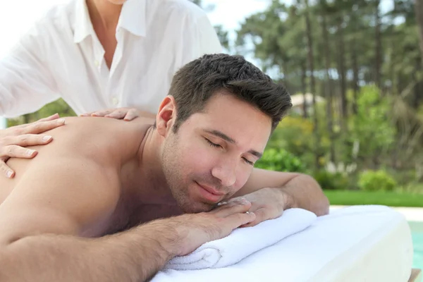 Człowiek ustanawiające łóżko do masażu — Zdjęcie stockowe