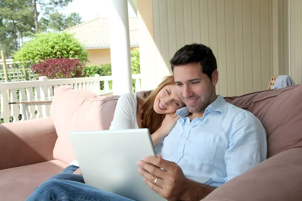 Paar sitzt mit Laptop auf Couch — Stockfoto