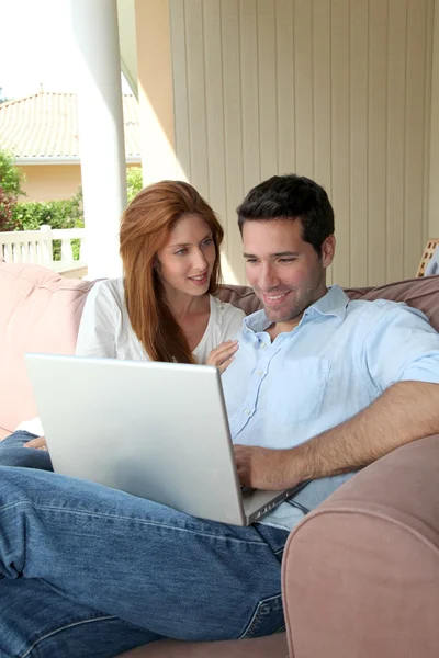 Paar zitten in de Bank met laptopcomputer — Stockfoto