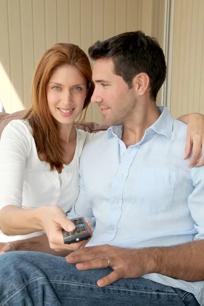 Paret sitter i soffan med TV-fjärrkontrollen — Stockfoto