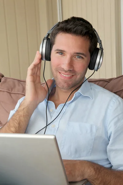 Handsome man listening to music on internet — Stock Photo, Image