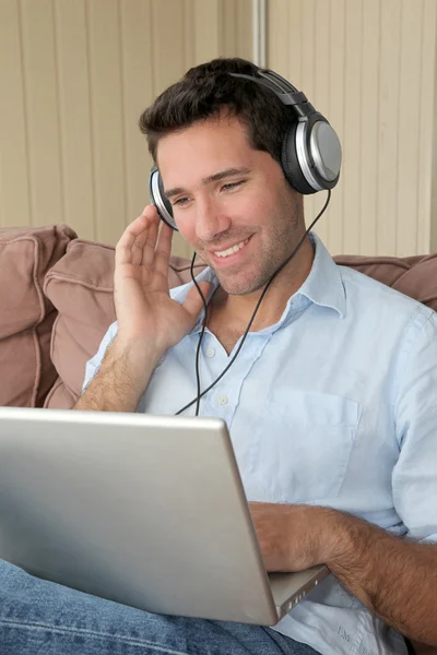 Knappe man luisteren naar muziek op internet — Stockfoto