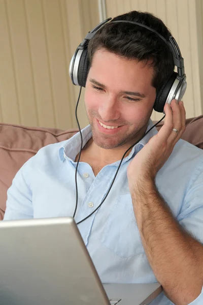 Handsome man listening to music on internet — Stock Photo, Image