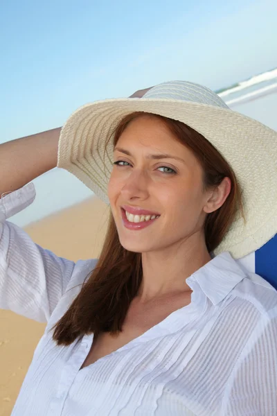 Красивая женщина отдыхает в шезлонге на пляже — стоковое фото
